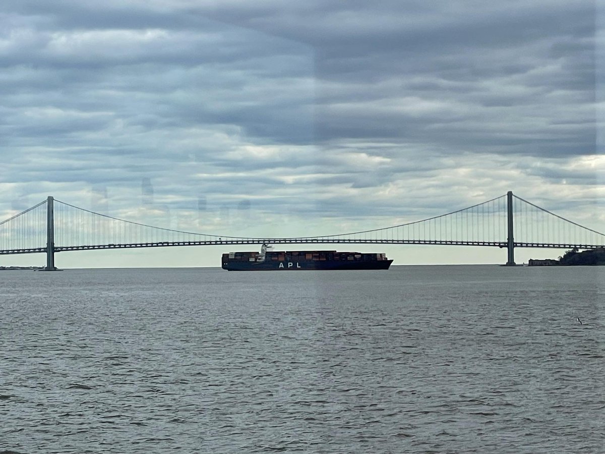 The 11,000-foot-long APL Qingdao sits by the Verrazzano Bridge, where it was towed on Friday night after losing propulsion.